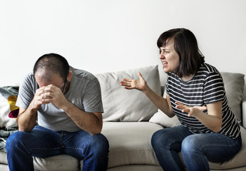 Unhappy couple arguing on the sofa