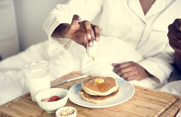 Obraz na płótnie Canvas A person having breakfast in bed