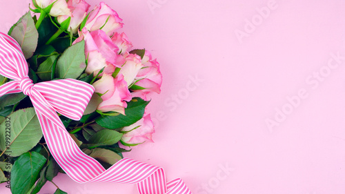Happy Mother's Day background of pink roses with copy space on pink wood table.