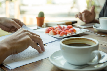 Businessmen hand holding pen reading documents