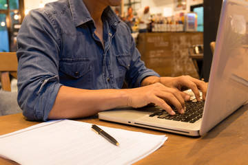 Young casual man working on laptop in cafe