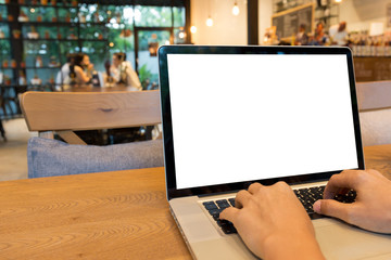Man hands typing on laptop with blank white screen on wooden table