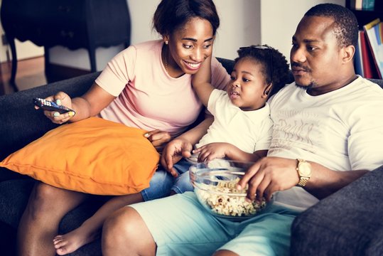 Black Family Eating Popcorn While Watching Movie At Home