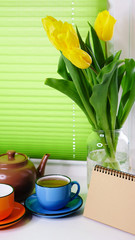 Yellow tulips and cup of tea