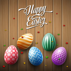 Happy Easter egg with confetti on a wooden brown background