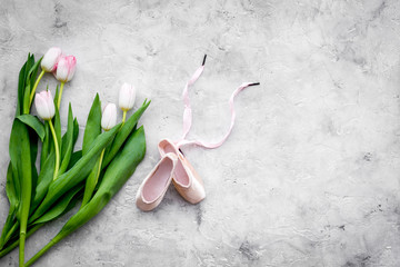 Ballet shoes near delicate flowers on grey background top view copy space