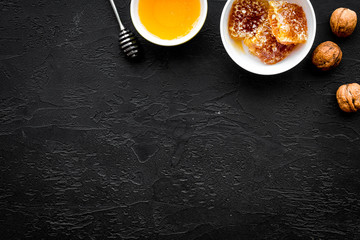 Fresh honey as dessert. Honey in bowl, honeycomb, nuts on black table top view copy space