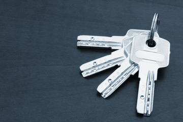 Bunch of silver coloured keys on dark table