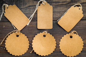 Figured blank tags for write price or discount on dark wooden background mockup pattern