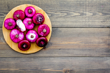 Red onion for salads on dark wooden background top view copy space