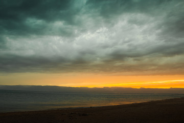 Naklejka na ściany i meble Line of sunset over the sea and sky with clouds