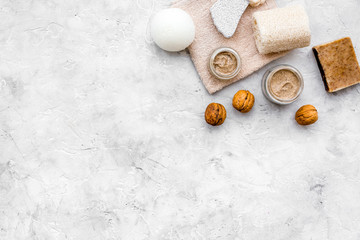 Obraz na płótnie Canvas organic scrub with walnut for homemade spa on stone background top view mockup