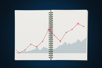Obraz premium Raising graph on opened notebook, on blue background