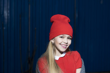 Child smiling with long blond hair outdoor, beauty. Small girl smile in red hat, fashion. Kid fashion trend and style. Baby beauty look and hairstyle. Happy childhood and youth