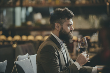 Man tasting wine in restaurant or bar interior