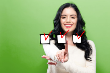 Checklist with young woman pointing on a green background