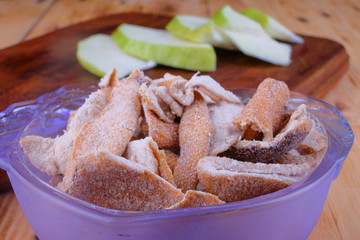 Sour orange peel and sliced guava on cutting board.
