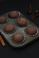 Just Baked Homebaked Chocolate Muffins for Dessert with colored Conffeti. Dark Background.