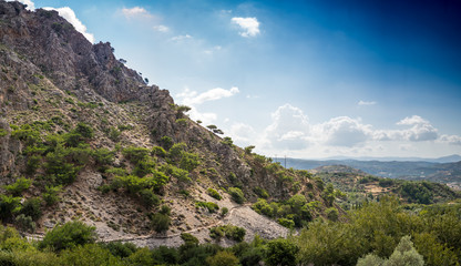 Field and mountain against cloudy sky