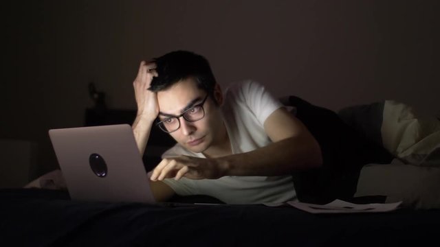 Working late at night in bed with a laptop.