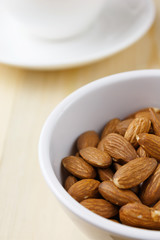 Roasted almonds in a cup placed on a wooden table