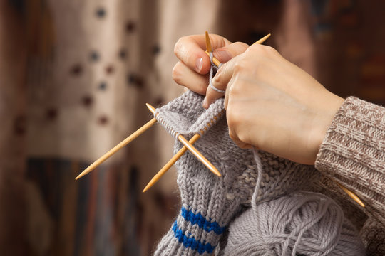 hands of woman knitting a sock