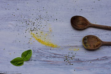 Colorful various spices whit wooden spoons at light wooden background 
