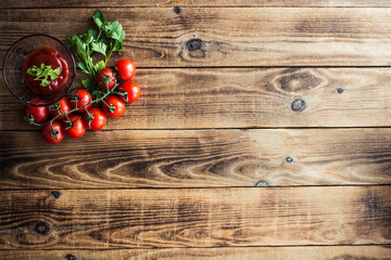 tomatoes with greens and sauce on wooden background