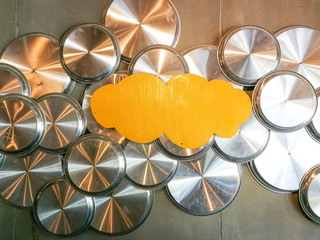 Abstract aluminium circle tray and yellow cloud-shaped wood plane hang on the wall.