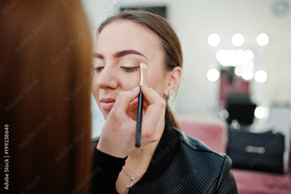 Wall mural Make up artist work in her beauty visage studio salon. Woman applying by professional make up master. Beauty club concept.