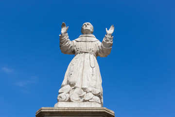 Fototapeta na wymiar A statue of Saint Wojciech against a cloudless blue sky