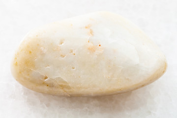 tumbled green agate gemstone on white marble