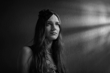 Dramatic portrait of a beautiful woman in hat with veil .