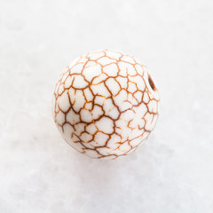 bead from cracked Cacholong gemstone on white