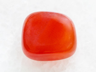 polished carnelian gem on white marble