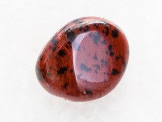 tumbled mahogany obsidian gemstone on white