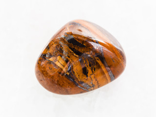 polished tigers eye gemstone on white marble