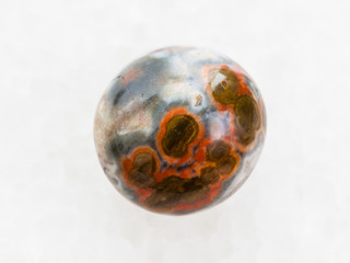 polished orbicular jasper gemstone on white marble