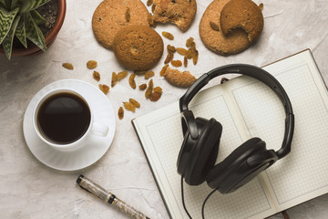 Cup of coffee Diary Cookies Flower in the pot Headphones on a light background. Concept of Education