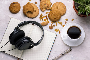 Cup of coffee Diary Cookies Flower in the pot Headphones on a light background. Concept of Education