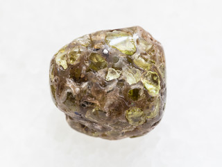 polished Peridot gemstone on dark white marble