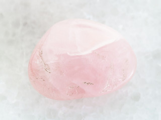 tumbled Rose Quartz gem stone on white marble