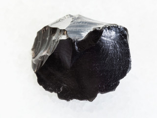 raw obsidian (volcanic glass) crystal on white