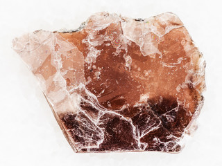 rough brown mica lamina on white marble