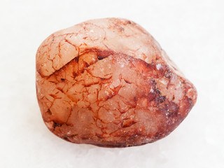 pebble of pink quartz stone on white marble