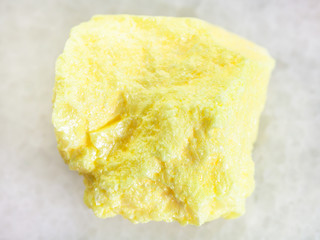 rough native Sulphur stone on white marble