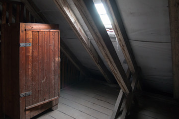 alter Holzschrank auf einem düsteren Dachboden