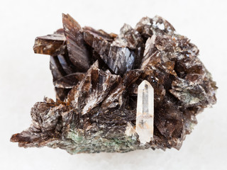 raw crystals of axinite stone on white marble