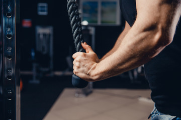 Close-up of man doing exercises on muscles of triceps in simulator. Muscles on arms, ligaments. Concept workout, bodybuilder in gym.