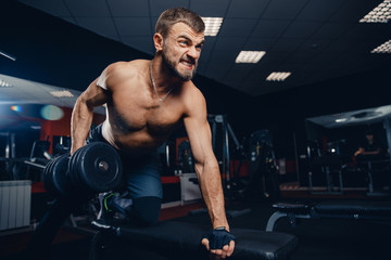 Workout man is doing triceps exercises with screaming, motivation. Concept strong man